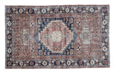 Distressed mid-20th century Oushak rug with navy medallion, blush rose, and sand geometric motifs.