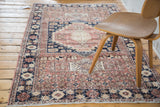 Distressed Turkish Oushak rug in blush rose, sand, and navy geometric patterns.