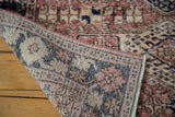 Distressed hand-knotted Oushak rug pile showcasing geometric floral patterns in blush and navy.