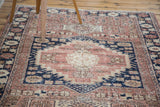 Distressed Oushak rug texture with blush, navy, ivory geometric patterns.
