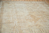 Distressed Mahal carpet texture with geometric quatrefoil and floral motifs in neutral ivory and brown.