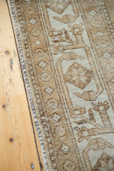 Distressed texture and geometric patterns on a neutral Mahal rug edge.
