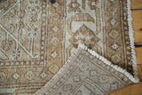 Distressed Persian Mahal rug corner with visible hand-knotted back, white fringe, and earth tone patterns.