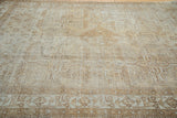Distressed Mahal carpet with faded geometric quatrefoil panels in neutral ivory and brown.