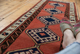 Faded brick red Sarab runner with navy, saffron yellow hexagonal diamond medallions.