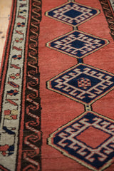 Sarab runner detail showing navy hexagonal medallions, brick red field, and water motif border.