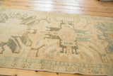 Hand-knotted texture of a vintage Oushak runner, featuring rectilinear patterns in faded teal and lemony gold.