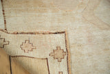 Oushak rug's folded corner reveals tightly woven geometric foundation and dense wool pile.