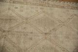 Distressed Oushak rug texture with tone-on-tone geometric pattern, abrash, and wear to knot heads.
