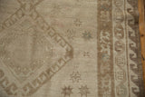 Distressed vintage Oushak rug detail showing neutral tone-on-tone geometric motifs and textural abrash.