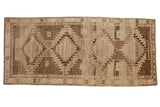 Vintage Oushak runner with bold serrated geometric medallions in brown and ivory tones, 5x11.