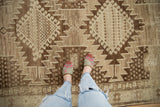 Hand-knotted vintage Oushak runner displaying serrated geometric medallions in rich brown and ivory.