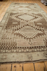 Angled view of vintage Oushak runner's serrated rectilinear pattern in brown and ivory tones.