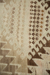 Textured pile of vintage Oushak rug, displaying serrated rectilinear patterns in beige and brown.