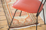 Geometric border and thick fringe on vintage Oushak rug, blush and orange tones.