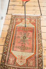 Vintage Oushak rug corner with blush, beige, and orange stylized geometric patterns.