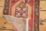 Vintage Oushak rug corner showing hand knotted weave, fringe, and rose palmette border.