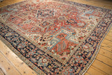 Vibrant geometric Heriz carpet design, featuring square medallions, herati border, and natural wear.