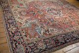 Vintage Heriz carpet showing its unusual herati border and vibrant geometric field patterns.