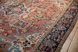 Hand-knotted geometric patterns, palmettes, and unique Herati border on vintage Heriz carpet.