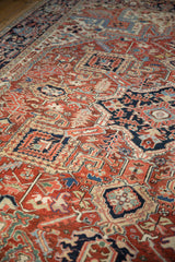 Detail of ornate geometric Heriz rug pattern with diverse reds, navy blue, and ivory.