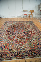 Intricate serrated stepped spandrels, brick red field, and contrasting borders on this Heriz carpet.