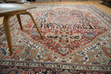 Serrated stepped spandrels on a vintage Heriz carpet, brick red, navy, ivory, side selvage, light wear.