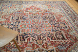 Ornate central medallion and stepped spandrels of vintage Heriz rug in brilliant red, navy, ivory.