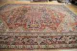 Vintage Heriz carpet detail: thickly banded serrated spandrels in red, navy, aqua.