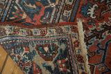 Heriz carpet corner showing original selvage, fringe, and geometric motifs in navy, red, and ivory.