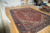 Vintage Heriz carpet featuring bold geometric palmettes in red, navy, and aqua.