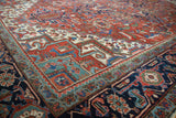 Geometric patterns of Vintage Heriz rug border in navy, brick red, aqua, and blush.