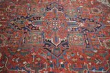 Detail of vintage Heriz rug's geometric pattern with brick red, navy, and aqua colors.