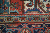 Geometric design detail of a vintage Heriz carpet with bold red, navy, and aqua colors.