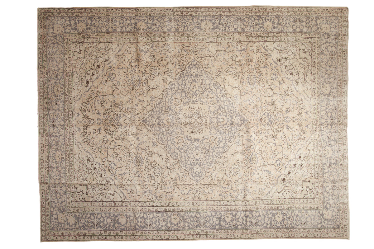 Hand-knotted distressed Oushak rug, antique ivory field with silver-grey central medallion.