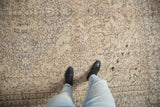 Distressed Oushak carpet with antique ivory and muted grey floral patterns underfoot.