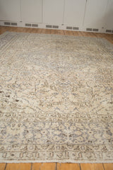 Decorative distressed texture and neutral silver-grey border of an Oushak carpet.