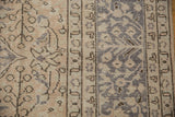 Distressed Oushak carpet showing faded antique ivory field with wooded tone motifs and silver grey border.
