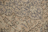 Distressed Oushak carpet's faded curvilinear pattern in antique ivory, beige, and silver-grey tones.