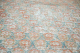 Faded terra cotta and blanched teal floral motifs on distressed Oushak rug pile.
