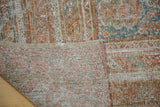 Distressed Oushak carpet's woven backing, secured edge, and faded cinnabar, teal pile detail.