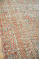 Distressed Ushak carpet featuring faded cinnabar and blanched aqua floral motifs.