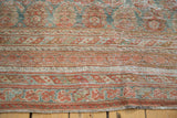 Faded cinnabar and blanched teal patterns on the distressed Oushak rug pile.