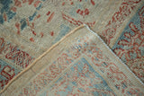Hand-knotted foundation and distressed pile of an Antique Sultanabad, showing muted blue and terracotta motifs.