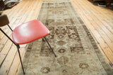 Vintage Oushak runner with repeating geometric Caucasian medallions and brown ivory tones.