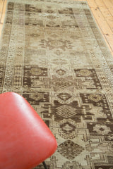 Geometric Caucasian medallions in brown, ivory, and subtle green on Vintage Oushak runner, with wear.