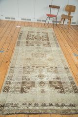 Geometric tribal medallions in wooded brown, ivory, and soft green tones with abrashes.