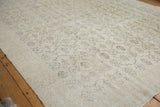 Distressed ivory beige Oushak carpet with subtle charcoal floral vinery and worn texture.