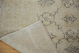 Hand-knotted back weave and distressed ivory beige Oushak carpet with charcoal vinery.