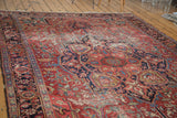 Distressed cherry red Ahar Heriz rug with geometric navy medallion and curvilinear motifs.